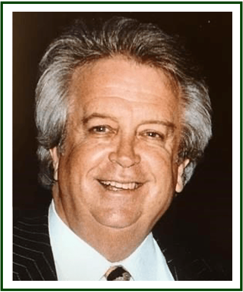 a man wearing a suit and tie smiling at the camera